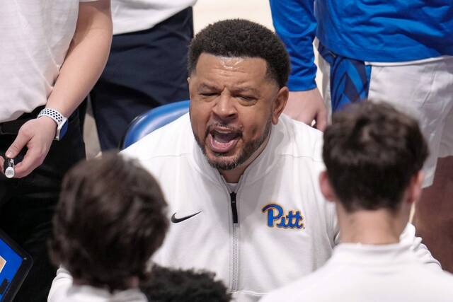 Pitt head coach Jeff Capel talks with his team during a timeout in the first half of an NCAA college basketball game against West Virginia, Friday, Nov. 15, 2024, in Pittsburgh.