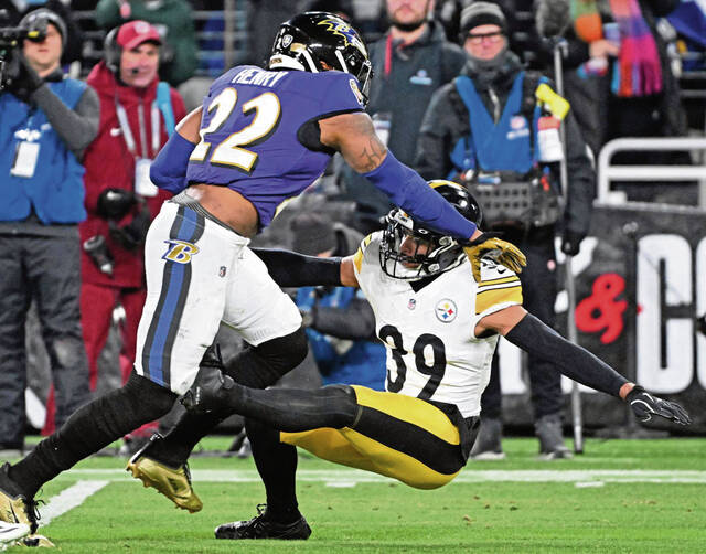 Ravens running back Derrick Henry stiff-arms the Steelers’ Minkah Fitzpatrick to the ground in the first quarter during the AFC Wild Card game Saturday at M&T Bank Stadium.