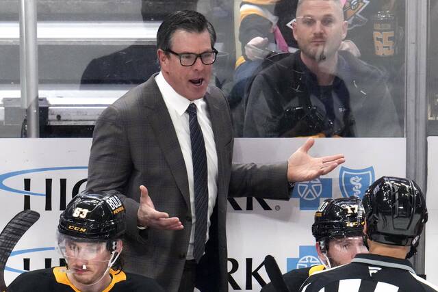 Penguins coach Mike Sullivan talks with linesman Bryan Pancich during the first period against the Lightning on Sunday.