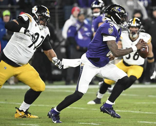 Ravens quarterback Lamar Jackson gets past the Steelers’ Cam Heyward in the first quarter during the AFC wild-card game Saturday.