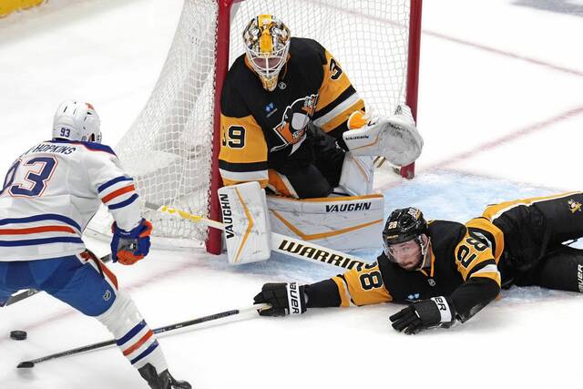 The Penguins’ Marcus Pettersson reaches to block a shot by the Oilers’ Ryan Nugent-Hopkins in front of Penguins goaltender Alex Nedeljkovic on Thursday.