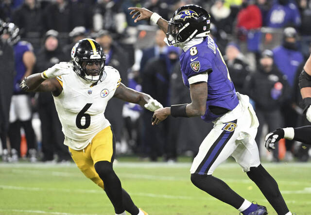 Ravens quarterback Lamar Jackson throws a touchdown pass to Justice Hills against the Steelers’ Patrick Queen in the second quarter of the AFC wild-card game Saturday at M&T Bank Stadium.