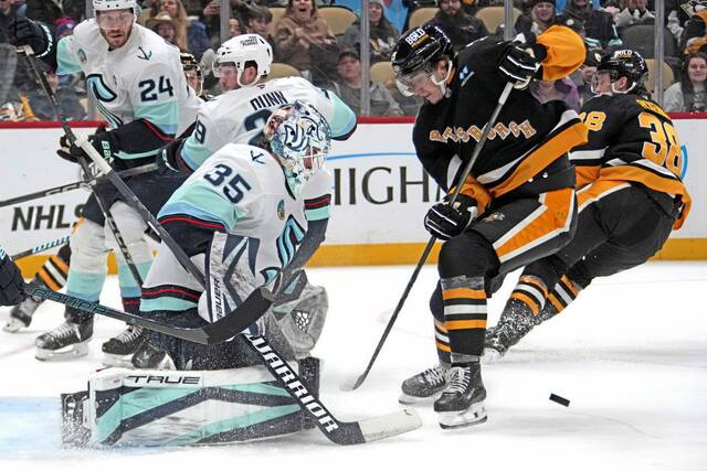 The Penguins’ Cody Glass (19) can’t get his stick on a rebound off Kraken goaltender Joey Daccord during the second period Tuesday.