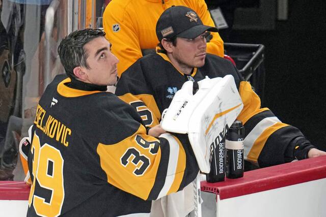 Penguins goaltenders Alex Nedeljkovic (left) and Tristan Jarry gather at the bench during a game at PPG Paints Arena Saturday.