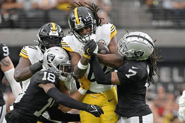 Pittsburgh Steelers running back Najee Harris runs against Las Vegas Raiders cornerback Jack Jones and safety Tre’von Moehrig during a game in Las Vegas, Sunday, Oct. 13, 2024.