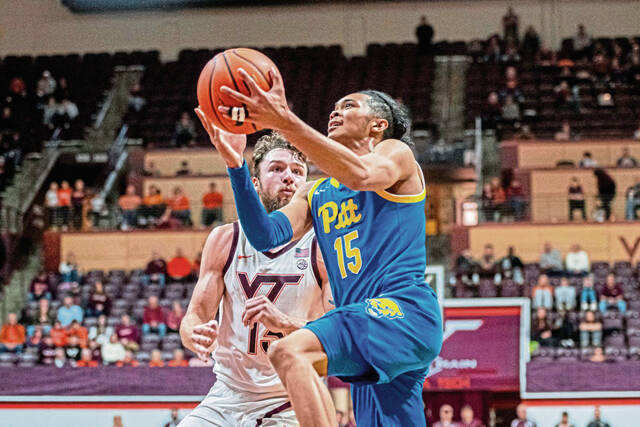 Pitt guard Jaland Lowe (15) drives by Virginia Tech forward Ben Burnham (13) during the second half of an NCAA college basketball game, Saturday, Dec. 7, 2024, in Blacksburg, Va.