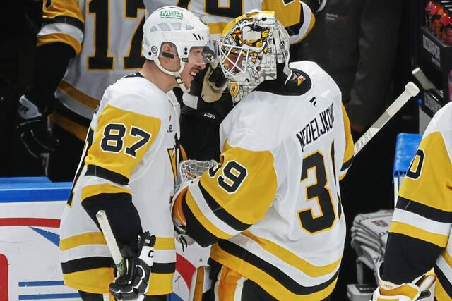 Penguins goaltender Alex Nedeljkovic and center Sidney Crosby celebrate a 5-2 victory over the Buffalo Sabres on Friday.