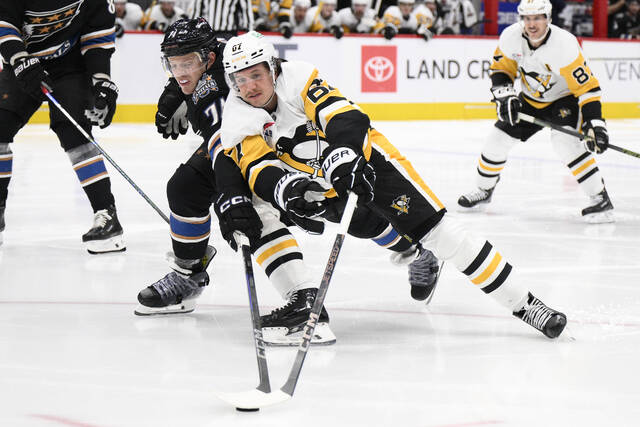 Capitals defenseman John Carlson (74) and Penguins right wing Rickard Rakell (67) battle for the puck during the second period Saturday.