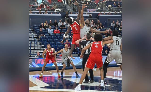 Duquesne’s Chabi Barre (5) battles Noel Brown of St. Bonaventure for the opening tipoff of an Atlantic 10 game Saturday.