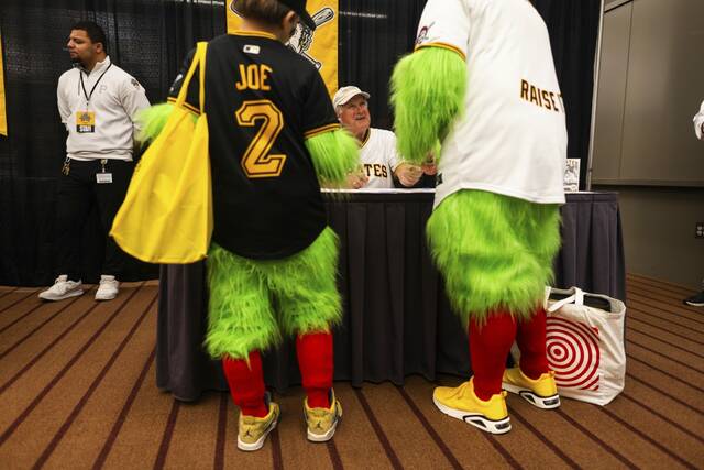 Former Pirates pitcher Steve Blass (center) signs autographs for fans Dan Srednicki of Allison Park and his son, Gunner, 12 (left) on Saturday at PiratesFest.