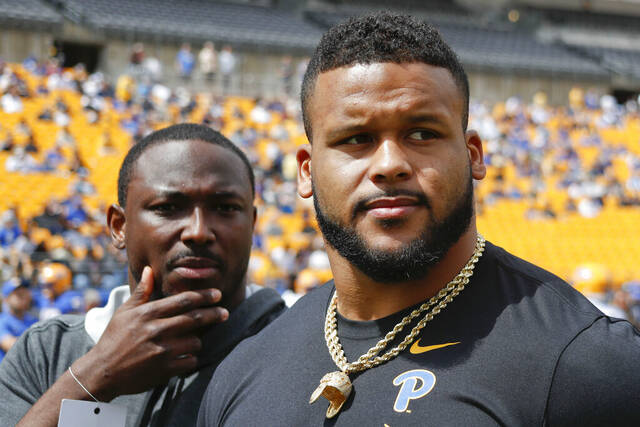 Former University of Pittsburgh football players, LeSean McCoy, left, and Aaron Donald look over the field before taking their roles as honorary coaches for the Pittsburgh annual intrasquad Blue-Gold spring football game in Pittsburgh.