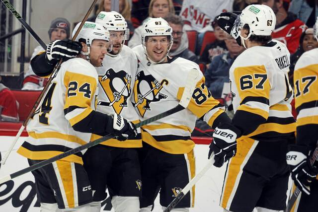 From left, Matt Grzelcyk, Erik Karlsson and Sidney Crosby celebrate Karlsson’s goal with Rickard Rakell against the Carolina Hurricanes on Jan. 5.