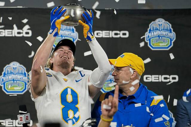 From Dec. 4, 2021: Pitt quarterback Kenny Pickett and head coach Pat Narduzzi celebrate their ACC championship win with the trophy after beating Wake Forest in Charlotte, N.C.