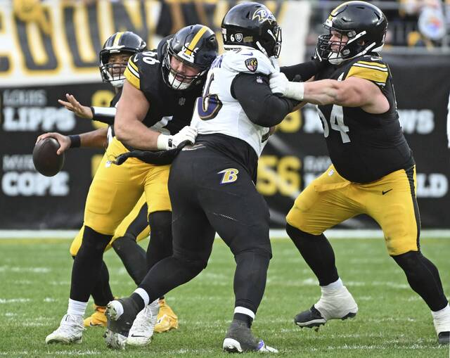 Steelers quarterback Russell Wilson looks to throw as Mason McCormick and Zach Frazier block against the Ravens in the fourth quarter Nov. 17, 2024 at Acrisure Stadium.