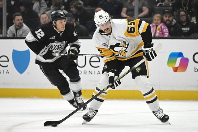 Penguins defenseman Erik Karlsson gets by Kings left wing Trevor Moore for a shot on goal during the first period Monday.