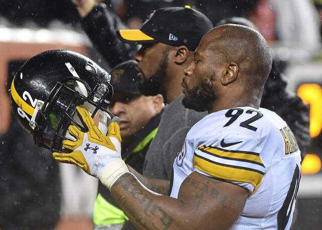 Steelers linebacker James Harrison and coach Mike Tomlin leave the field after an 18-16 victory over the Bengals in an AFC wild-card playoff game on Jan. 9, 2016, at Paul Brown Stadium in Cincinnati.