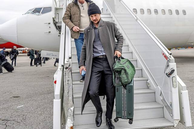 Penguins defenseman Erik Karlsson exits a team flight during the 2024-25 season.