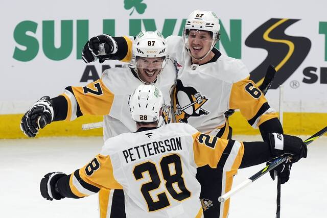 The Penguins’ Rickard Rakell (center) celebrates after his goal with Sidney Crosby (right) and Marcus Pettersson during the second period Friday, Nov. 29, 2024.