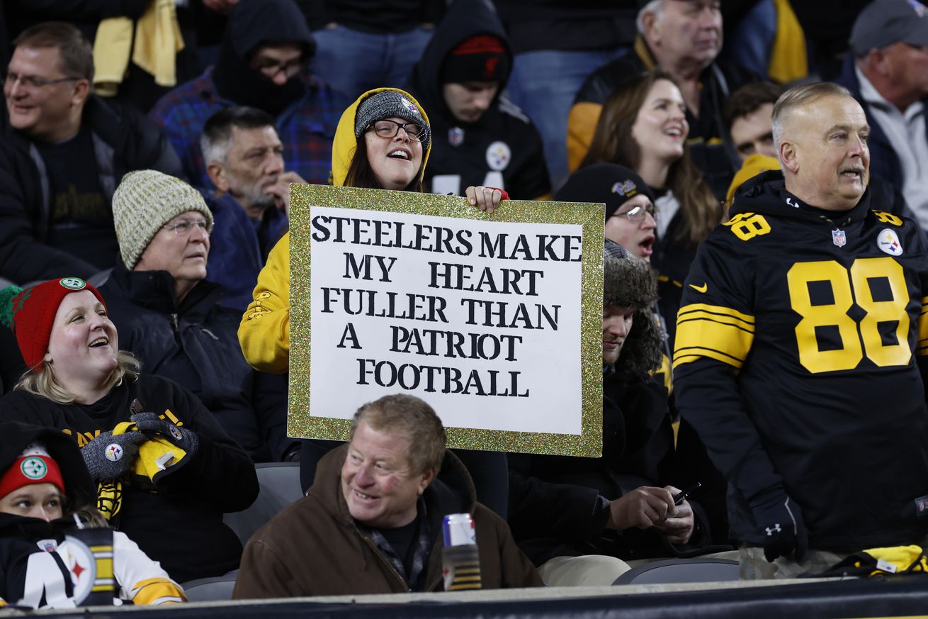 A Pittsburgh Steelers fan holds a sign that reads “Steelers Make My Heart Fuller Than A Patriot Football”. The Steelers lost to the New England Patriots, 21-18.